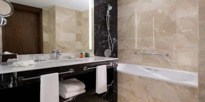 clean and spacious king bathroom with bath and shower at Hilton Astana.