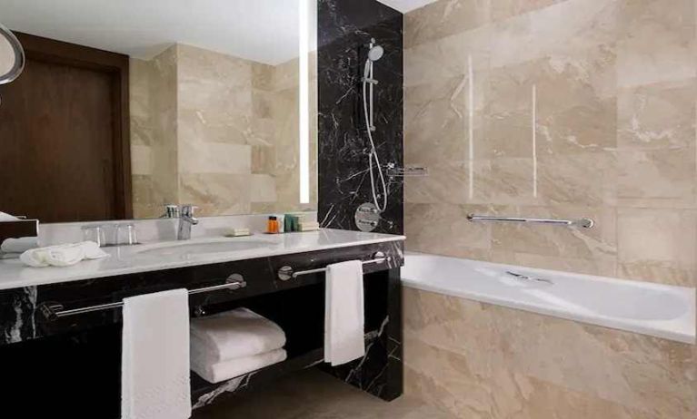 clean and spacious king bathroom with bath and shower at Hilton Astana.