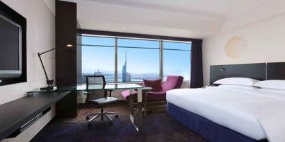 spacious king room with TV, work desk, chair, and couch at Hilton Fukuoka Sea Hawk.