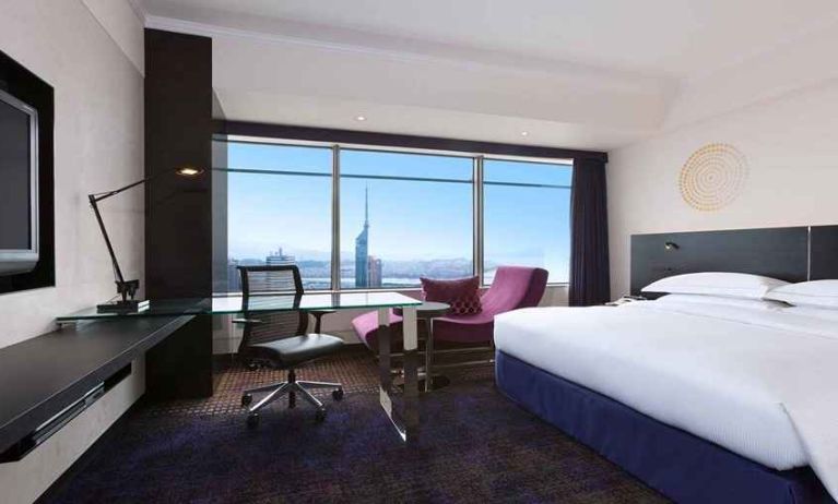 spacious king room with TV, work desk, chair, and couch at Hilton Fukuoka Sea Hawk.