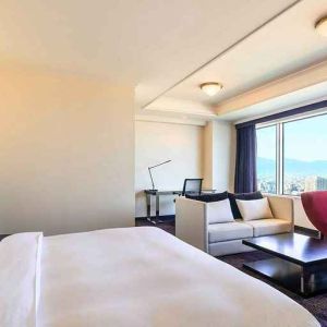 luxurious king suite with lounge area, business desk, and chair at Hilton Fukuoka Sea Hawk.