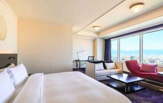 luxurious king suite with lounge area, business desk, and chair at Hilton Fukuoka Sea Hawk.