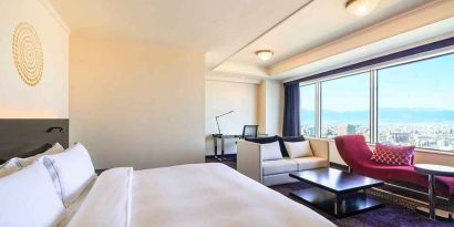 luxurious king suite with lounge area, business desk, and chair at Hilton Fukuoka Sea Hawk.