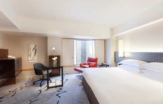 spacious king suite with TV, business desk, and couch at Hilton Tokyo.