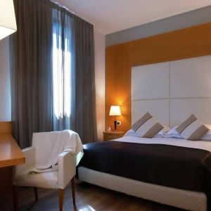 comfortable king suite with table, chair, and TV at Hilton Garden Inn Milan Malpensa.