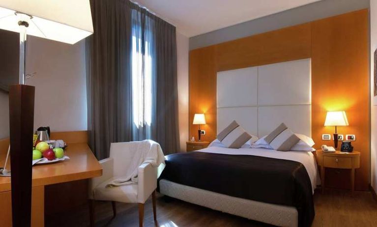 comfortable king suite with table, chair, and TV at Hilton Garden Inn Milan Malpensa.