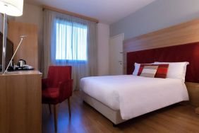 delux king room with TV, desk, and chair at Hilton Garden Inn Milan Malpensa.