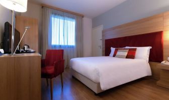 delux king room with TV, desk, and chair at Hilton Garden Inn Milan Malpensa.