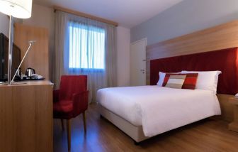 delux king room with TV, desk, and chair at Hilton Garden Inn Milan Malpensa.