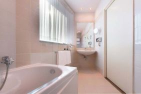 clean and spcious bathroom with bath and shower at Hilton Garden Inn Milan Malpensa.