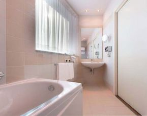 clean and spcious bathroom with bath and shower at Hilton Garden Inn Milan Malpensa.