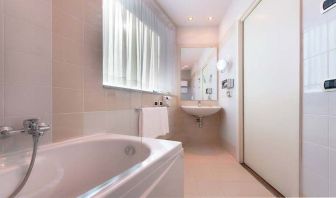 clean and spcious bathroom with bath and shower at Hilton Garden Inn Milan Malpensa.