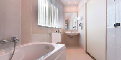 clean and spcious bathroom with bath and shower at Hilton Garden Inn Milan Malpensa.