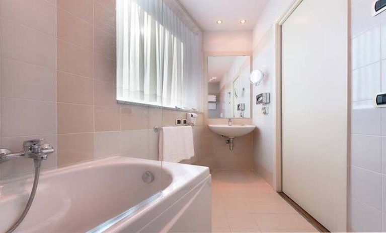 clean and spcious bathroom with bath and shower at Hilton Garden Inn Milan Malpensa.