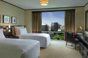 Twin room with TV screen and desk at the Conrad Bangkok.