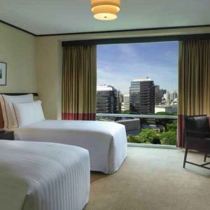 Twin room with TV screen and desk at the Conrad Bangkok.