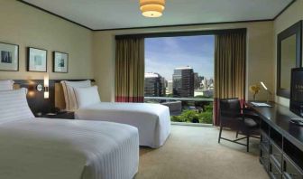 Twin room with TV screen and desk at the Conrad Bangkok.