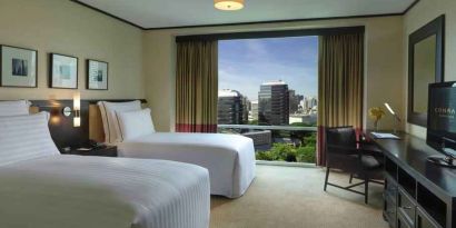 Twin room with TV screen and desk at the Conrad Bangkok.