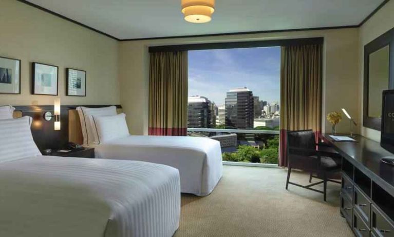 Twin room with TV screen and desk at the Conrad Bangkok.