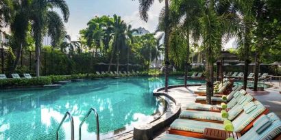 Beautiful outdoor pool with lounges at the Conrad Bangkok.