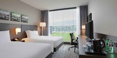 Twin room with desk and TV screen at the Hilton Garden Inn Zurich Limmattal.