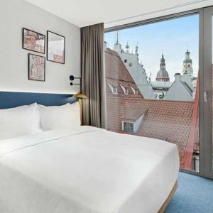 lovely delux king bedroom with chair and desk and lots of natural light at Hilton Garden Inn Riga Old Town.