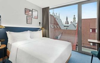 lovely delux king bedroom with chair and desk and lots of natural light at Hilton Garden Inn Riga Old Town.