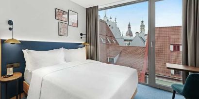 lovely delux king bedroom with chair and desk and lots of natural light at Hilton Garden Inn Riga Old Town.