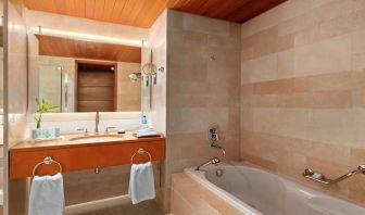 clean and spacious bathroom with bath at Hilton Kuwait Resort.