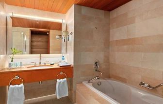 clean and spacious bathroom with bath at Hilton Kuwait Resort.