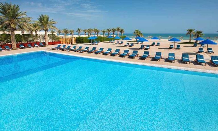 stunning outdoor pool with sunbeds at Hilton Kuwait Resort.