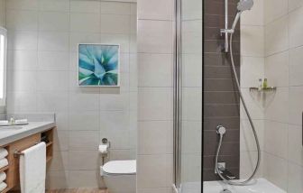 clean and spacious bathroom with shower and bath combo at Hilton Garden Inn Kuwait.