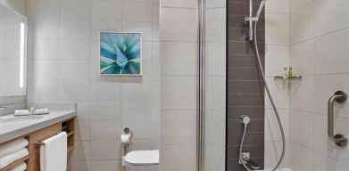 clean and spacious bathroom with shower and bath combo at Hilton Garden Inn Kuwait.