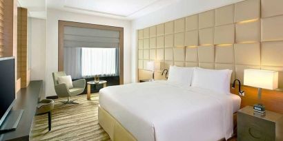 spacious king room with TV, desk, chair, and couch at DoubleTree by Hilton Riyadh - Al Muroj Business Gate.