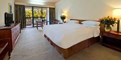 lovely king bedroom with TV and outdoor terrace at Hilton Addis Ababa.