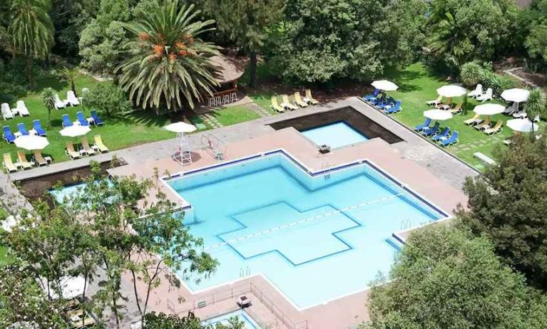 stunning outdoor pool with sun beds and umbrellas at Hilton Addis Ababa.