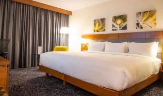 delux king room with couch, chair, and work desk at Hilton Garden Inn Nairobi Airport.