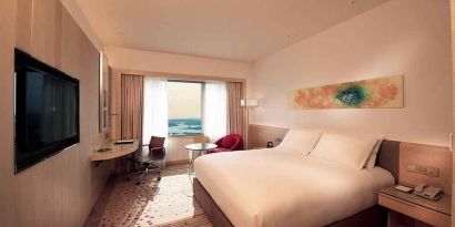 spacious king room with TV, work desk, and chair at DoubleTree by Hilton Hotel Johor Bahru.