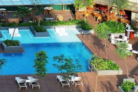 stunning outdoor pool surrounded by sun beds and seating area at DoubleTree by Hilton Hotel Johor Bahru.