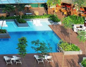 stunning outdoor pool surrounded by sun beds and seating area at DoubleTree by Hilton Hotel Johor Bahru.