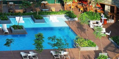 stunning outdoor pool surrounded by sun beds and seating area at DoubleTree by Hilton Hotel Johor Bahru.