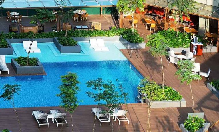 stunning outdoor pool surrounded by sun beds and seating area at DoubleTree by Hilton Hotel Johor Bahru.