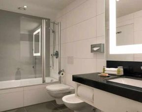 clean and spacious king bathroom with bath and shower combo at DoubleTree by Hilton Luxembourg.