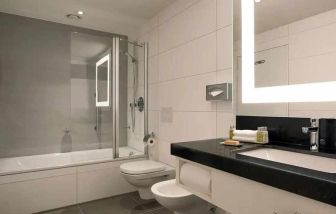 clean and spacious king bathroom with bath and shower combo at DoubleTree by Hilton Luxembourg.