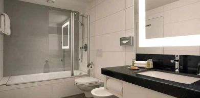 clean and spacious king bathroom with bath and shower combo at DoubleTree by Hilton Luxembourg.