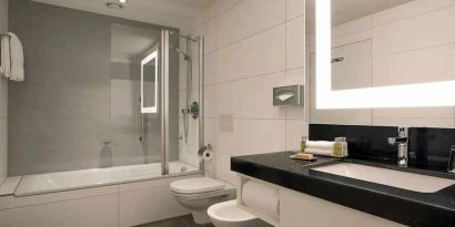 clean and spacious king bathroom with bath and shower combo at DoubleTree by Hilton Luxembourg.