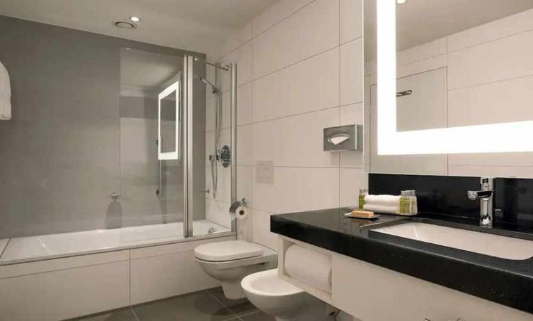 clean and spacious king bathroom with bath and shower combo at DoubleTree by Hilton Luxembourg.