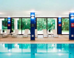 indoor pool with surrounding sunbeds at DoubleTree by Hilton Luxembourg.