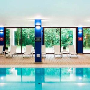 indoor pool with surrounding sunbeds at DoubleTree by Hilton Luxembourg.