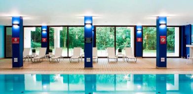 indoor pool with surrounding sunbeds at DoubleTree by Hilton Luxembourg.